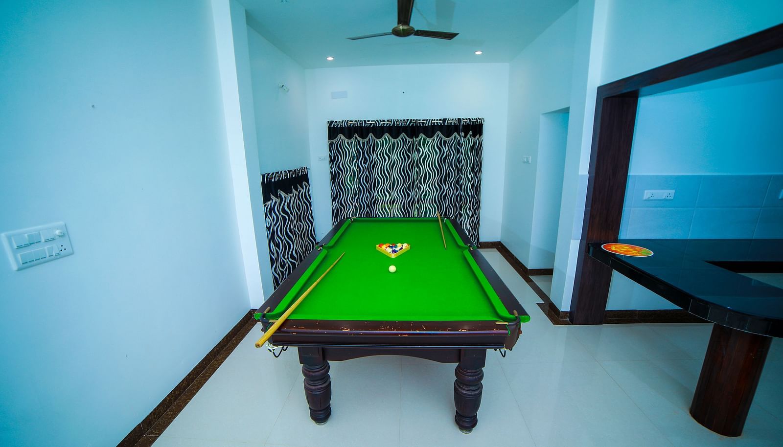 Image of a snooker table with a ceiling fan above it at WOW Bison Woods.